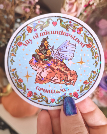 Pegatina holográfica "Aliado de Criaturas Incomprendidas" | Ilustración de sapo y polilla cottagecore